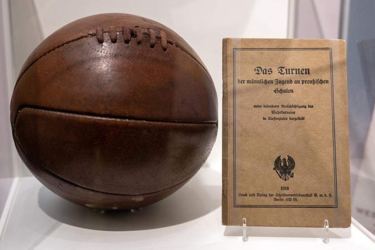 A soccer ball with 8-panel construction, circa 1890-1920, and a 1918 German pamphlet are displayed in a new exhibition called “The Beautiful Game.” The exhibit, highlighting the role of soccer (”football”) during World War I, is shown at the National WWI Museum and Memorial on Wednesday, April 1, 2026, in Kansas City.