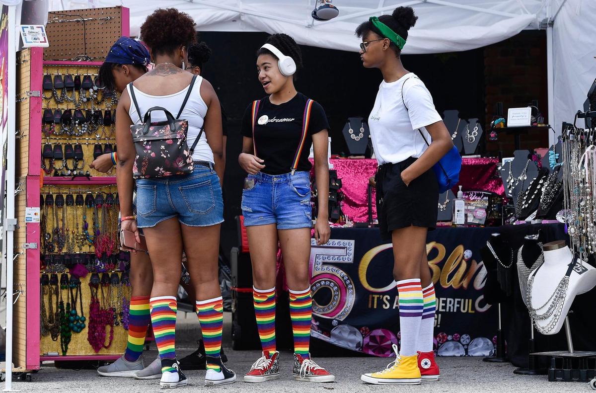 Members of the Hairston and Dyer families of Kansas City, Kansas, including Skye Dyer, from left; her aunt Tiffany Hairston; Skye’s sister Auriana Dyer; and Tiffany’s daughter Saniya Hairston browse jewelry at the first Pride on the Vine 2021 at the 18th and Vine Jazz District Saturday, June 26, 2021. They wore rainbow socks and came to the event to support Auriana, center, who came out as pansexual in the seventh grade. It’s Auriana’s first pride event.
