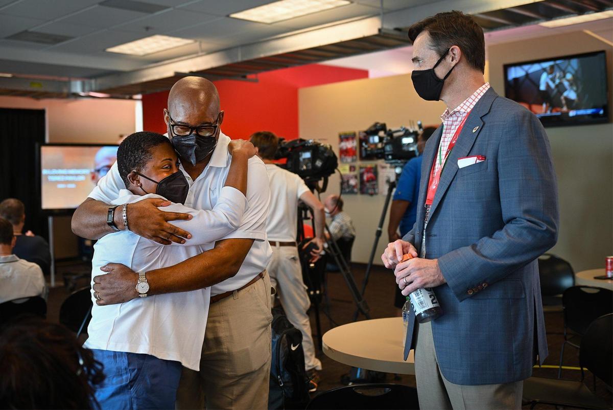 Ebony Reed, left, and Sharmyn Elliott, fiancee’ and father of Terez A. Paylor embraced as Mark Donovan, right, president of The Kansas City Chiefs, spoke to the pair before the Chiefs paid tribute to Paylor by retiring his press box seat and presenting a check to the Terez A. Paylor Scholarship at Howard University during a ceremony Friday, Aug. 27, at Arrowhead Stadium in Kansas City.