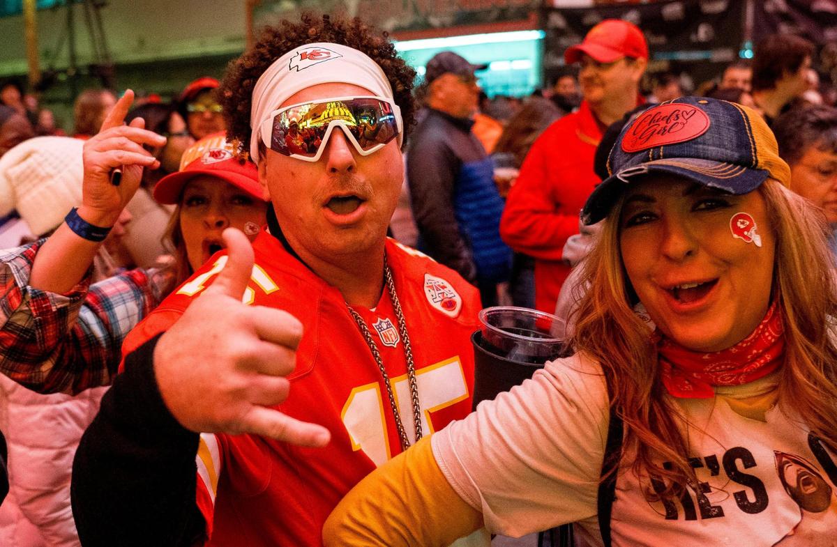 Sarah Massie, right, John Crocker and Dana Ellison party along Fremont Street during a fan gathering on Saturday, Feb. 10, 2024, in Las Vegas.