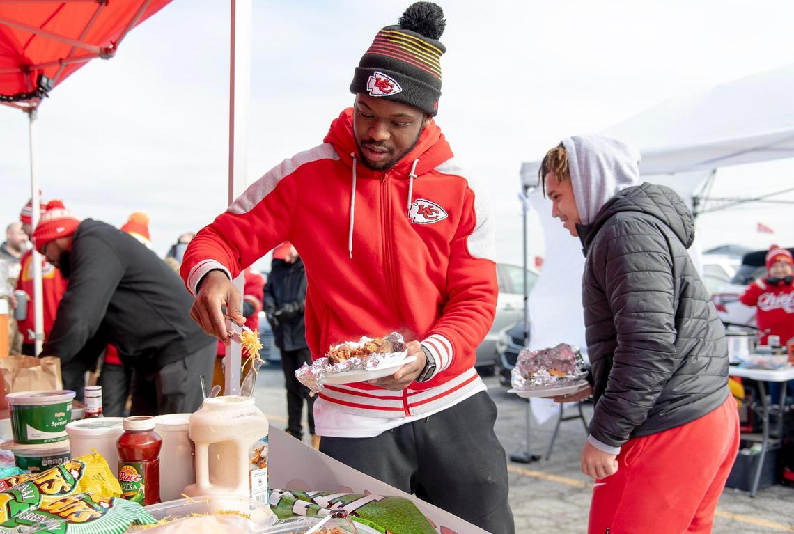 Montel Jones adds cheese to his baked potato at a “KC Chiefs Potato Girl” tailgating event outside Arrowhead Stadium before the Kansas City Chiefs and Cincinnati Bengals AFC Championship football game on Sunday, Jan. 29, 2023, in Kansas City.