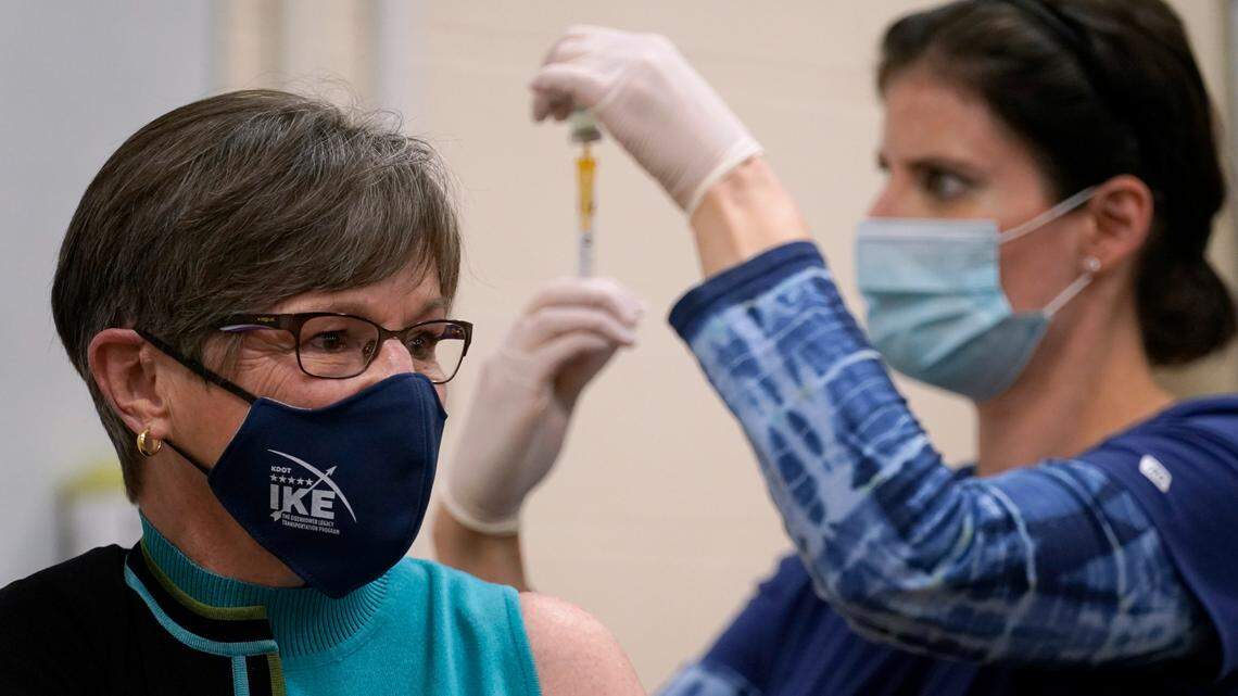 Public health nurse Lisa Horn prepares to give a COVID-19 vaccine injection to Kansas Gov. Laura Kelly on Wednesday in Topeka.