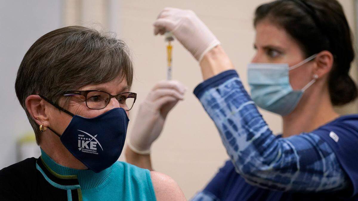 Public health nurse Lisa Horn prepares to give a COVID-19 vaccine injection to Kansas Democratic Gov. Laura Kelly Wednesday, Dec. 30, 2020, in Topeka, Kan.