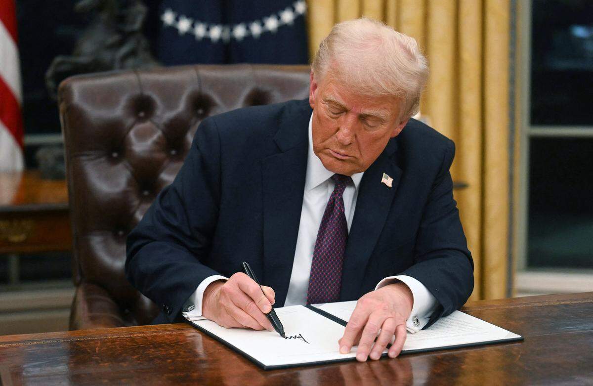 U.S. President Donald Trump signs an executive order in the Oval Office of the White House in Washington, D.C., on Jan. 20, 2025. (Jim Watson/Pool/AFP/Getty Images/TNS)