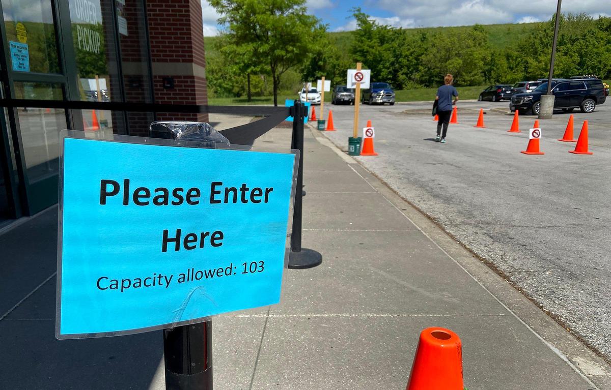 The capacity of Dick’s Sporting Goods in Zona Rosa is clearly posted outside the entrance. The cones on the right indicate one-way traffic for curbside service.