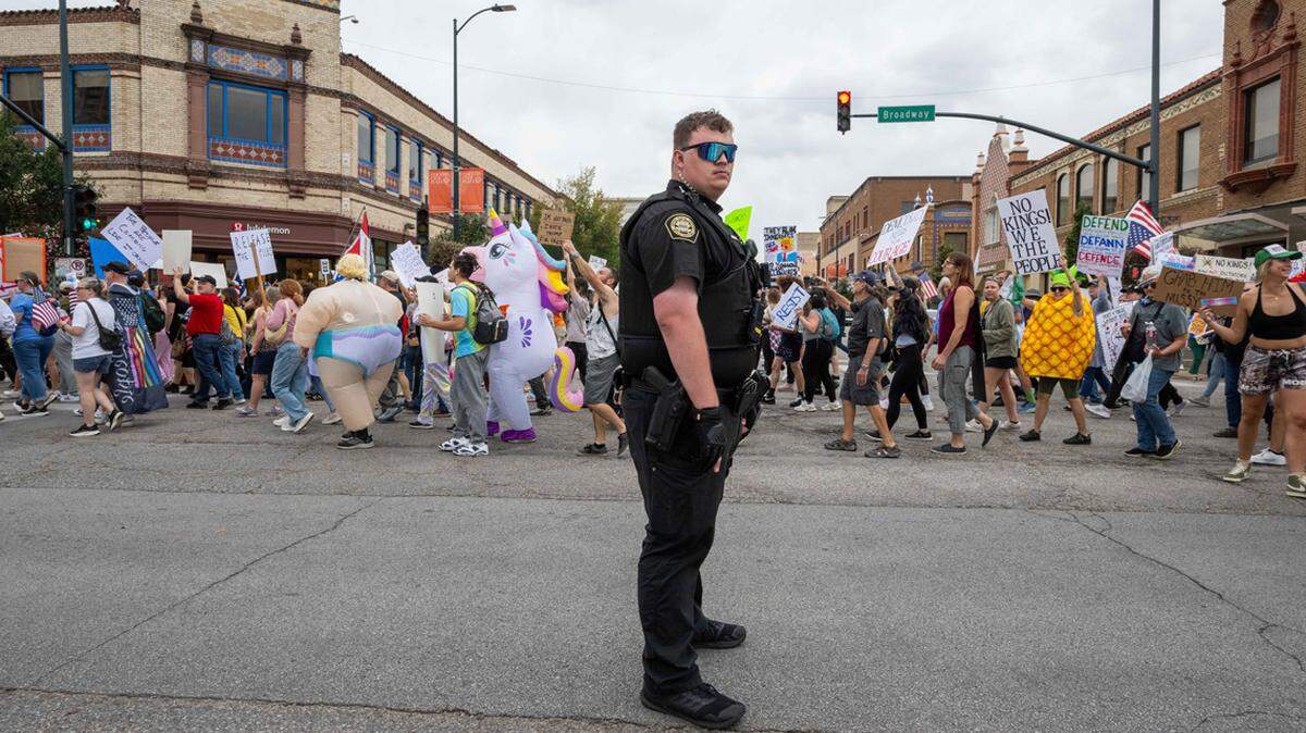 Plaza security keeps a close eye on protesters marching through the Country Club Plaza on Oct. 18, 2025.