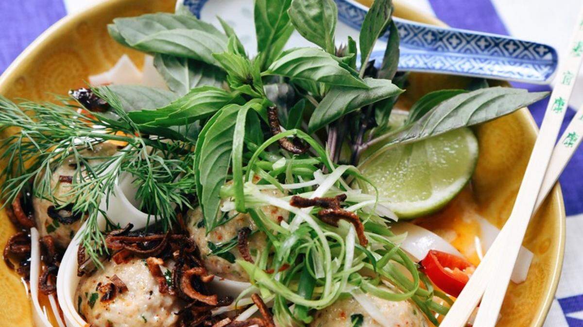 Hemma Hemma’s makrut lime scented chicken meatballs with red curry coconut broth, rice noodles and fresh herbs.