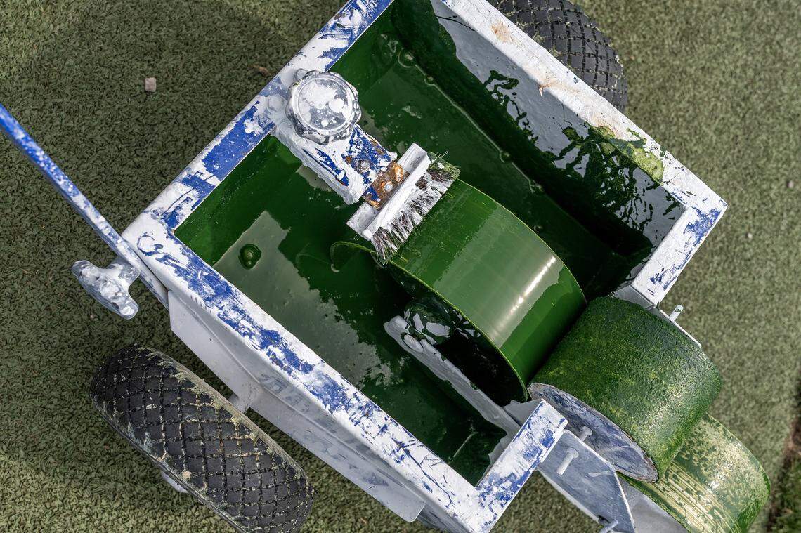 Green paint sits inside a field-marking machine used to cover white field markings in preparation for rugby at CPKC Stadium on Tuesday, April 14, 2026, in Kansas City.
