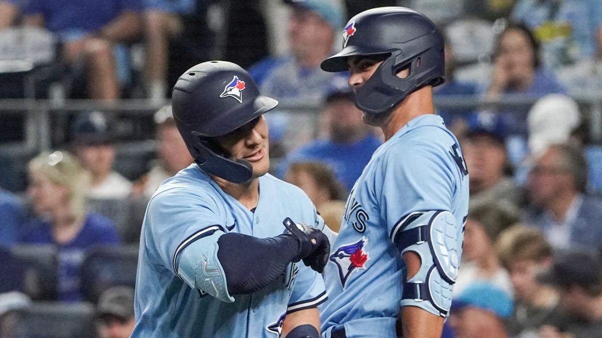Toronto Blue Jays left fielder Daulton Varsho (25) celebrates with right fielder Whit Merrifield (15) against the Kansas City Royals after hitting a solo home run in the sixth inning at Kauffman Stadium on April 4, 2023.