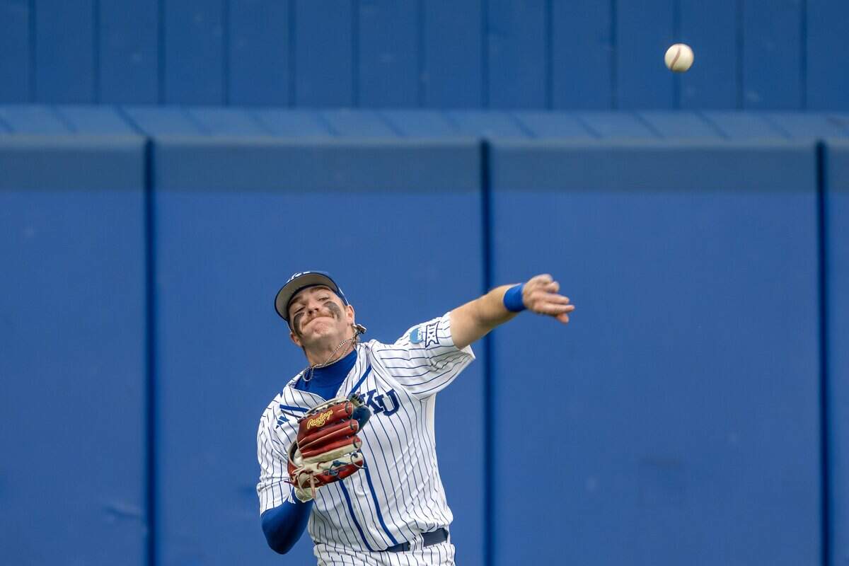 Kansas utility player Brady Ballinger (26) throws to the infield after teammate Tyson Owens (5) misses a catch in the fifth inning during an NCAA Tournament baseball game against Oklahoma at Hoglund Ballpark on Saturday, June 6, 2026, in Lawrence.