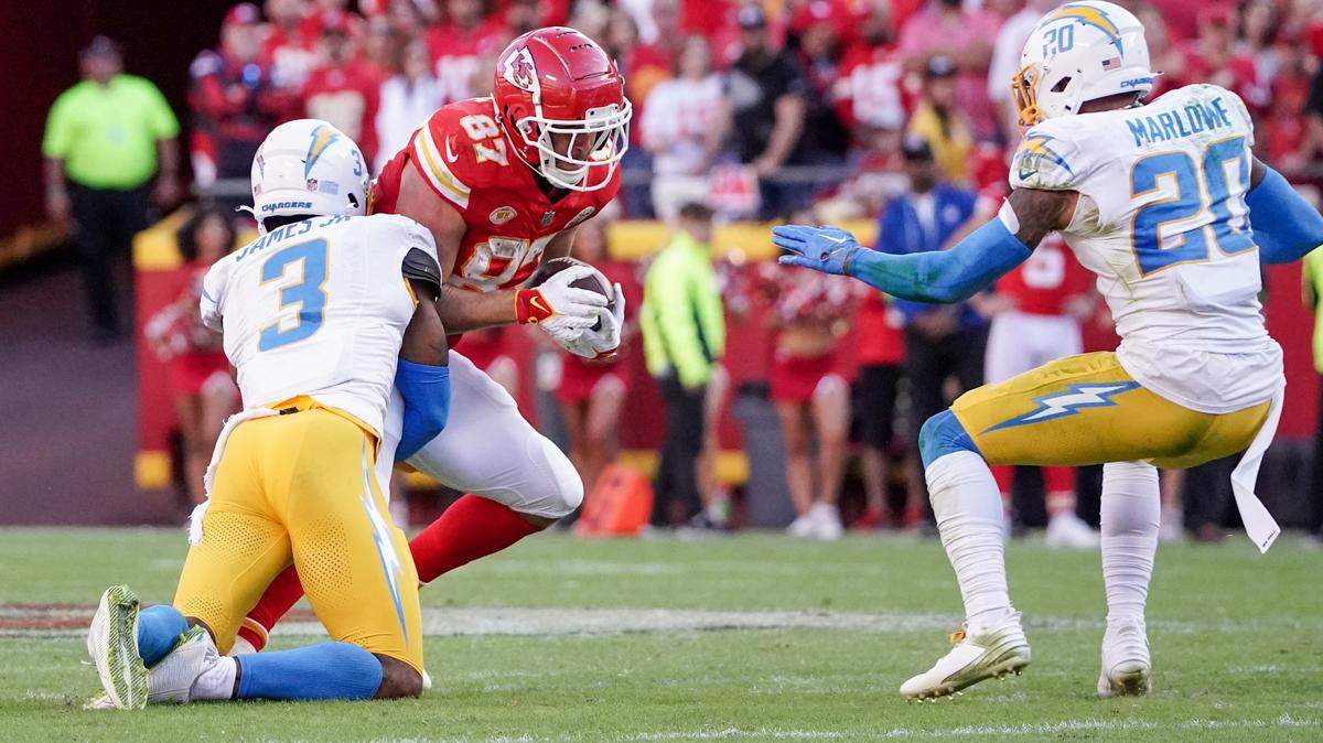 Kansas City Chiefs tight end Travis Kelce runs the ball as Los Angeles Chargers safety Derwin James Jr.makes the tackle during Sunday’s game. Mic’d-up video shows how often James and Kelce talked while playing.