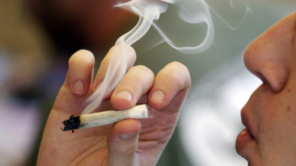 FILE - In this 2016 file photo a man smokes a marijuana joint at a party celebrating weed in Seattle.