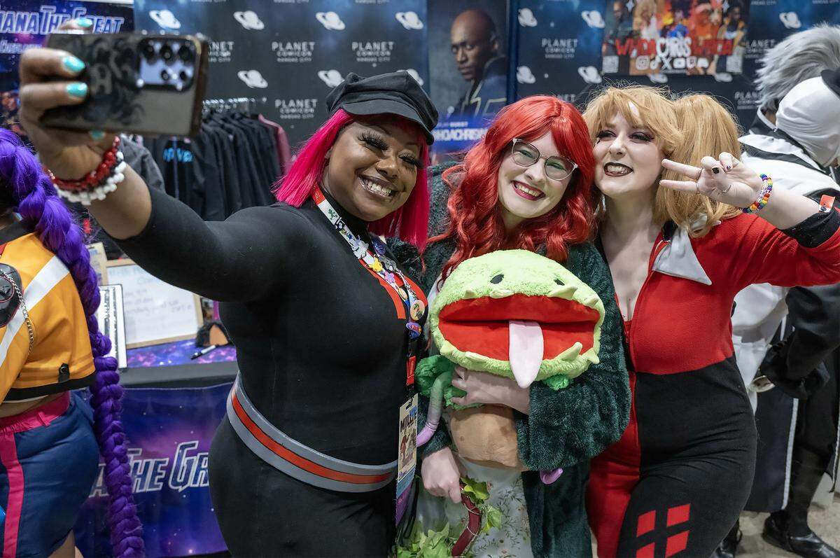 Diana "the Great" Alexander (right) takes a selfie with Cassie Wesson of Kansas City and Kimberly Wood of Shawnee Sunday, March 29, 2026, of Planet Comicon Kansas City. Wesson and Wood attended the Sunday festivities at Bartle Hall dressed as Superpower Poison Ivy and Sleepover Harley Quinn, respectively.