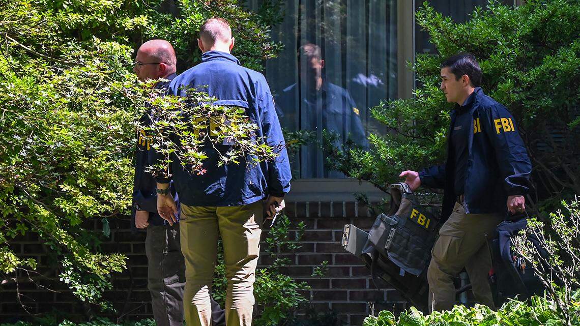FBI agents emerge after conducting a search at the home of former national security adviser John Bolton on Aug. 22.  
