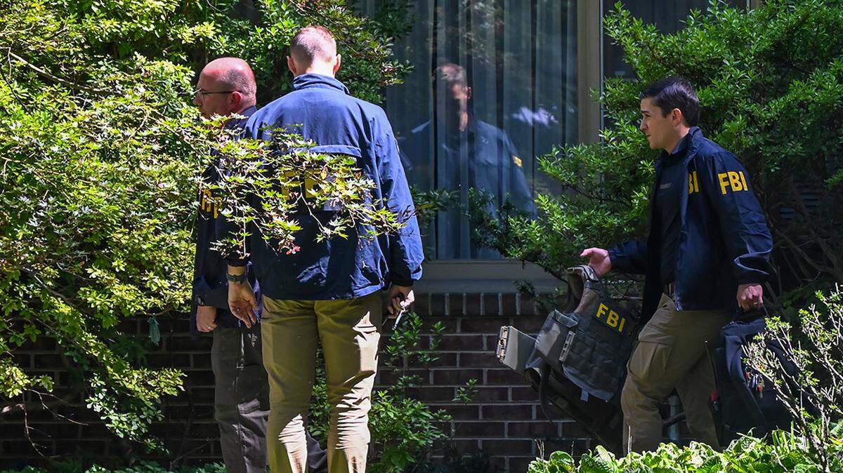 FBI agents emerge after conducting a search at the home of former national security adviser John Bolton on Aug. 22.  
