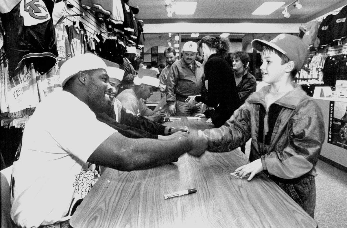 After signing an autograph, Chiefs running back Christian Okoye shook the hand of 9-year-old Phil Walter of Olathe in 1991 at Merle Harmon’s Fan Fair in the Indian Springs Shopping Center.