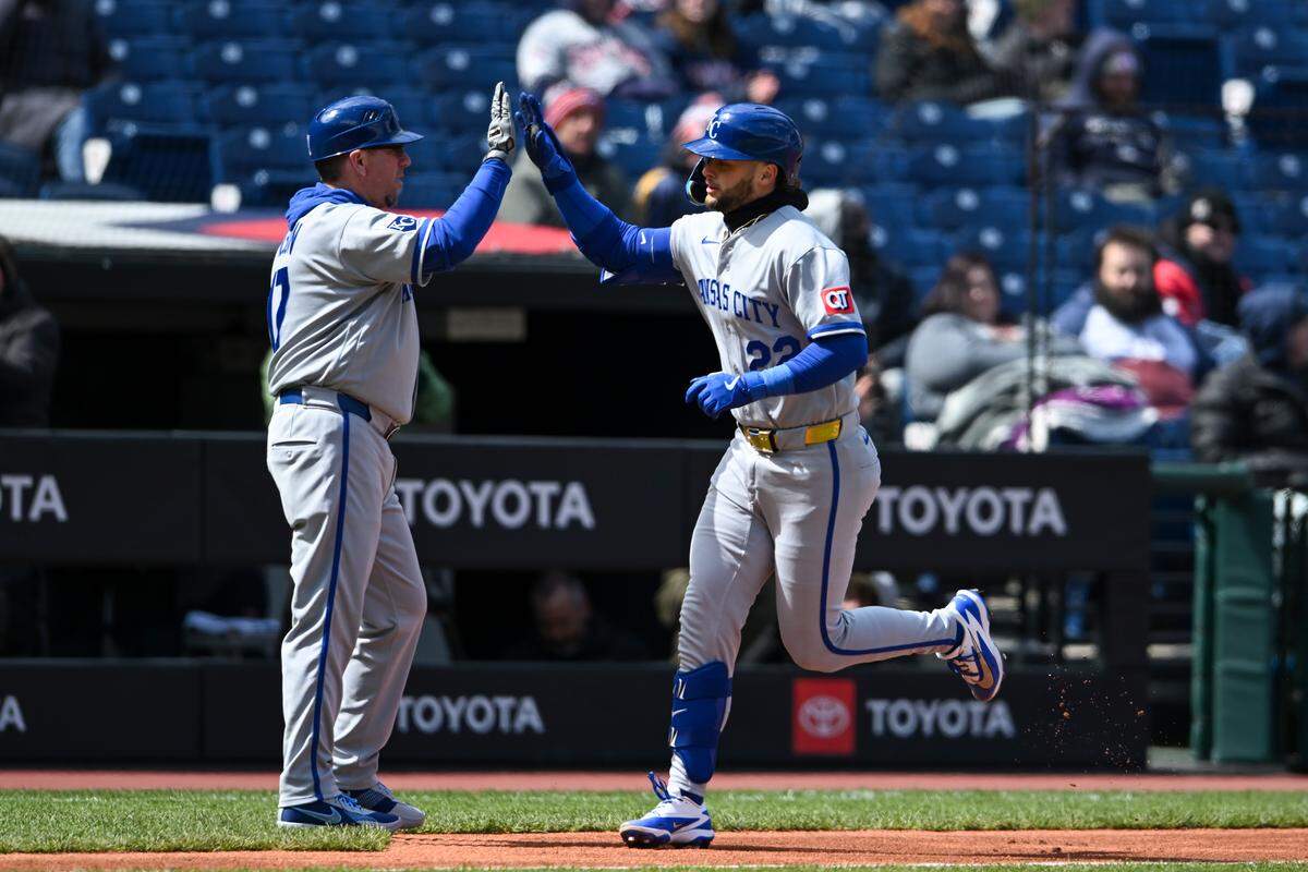 Carter Jensen #22 and third base coach Vance Wilson #17 of the Kansas City Royals celebrate a solo home run hit by Jensen during the second inning against the Cleveland Guardians at Progressive Field on April 07, 2026 in Cleveland, Ohio.