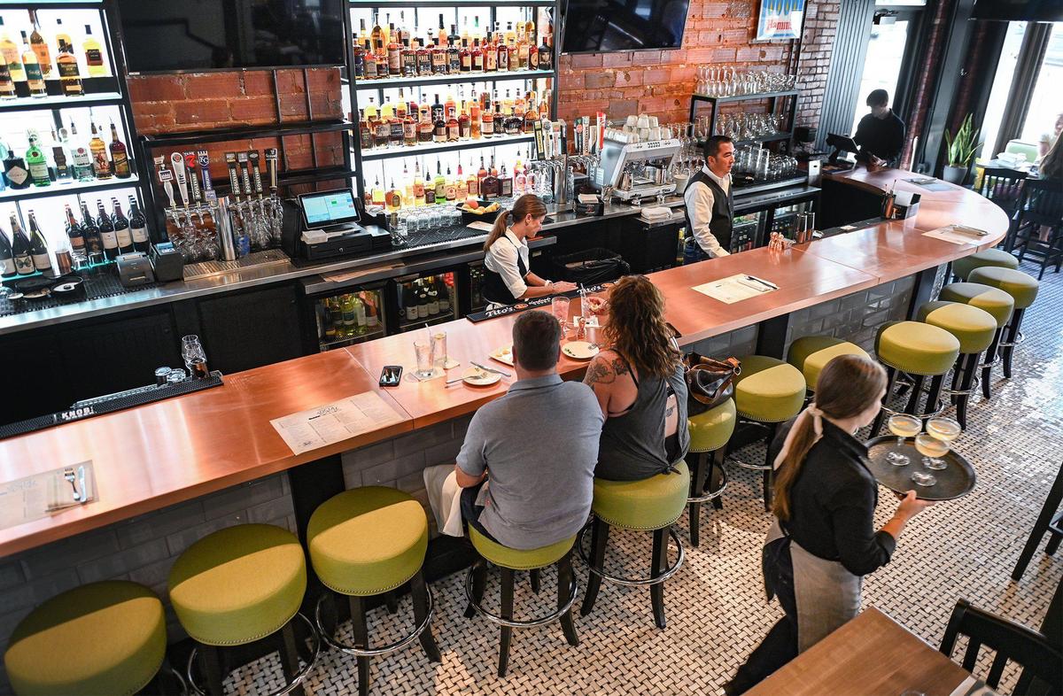 Guests dine at a large copper bar on the first floor at Third Street Social, 5031 Main St., in Kansas City.