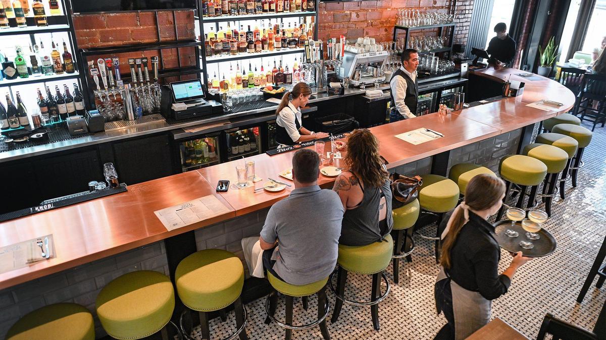 Guests dine at a large copper bar on the first floor at Third Street Social, 5031 Main St., in Kansas City.
