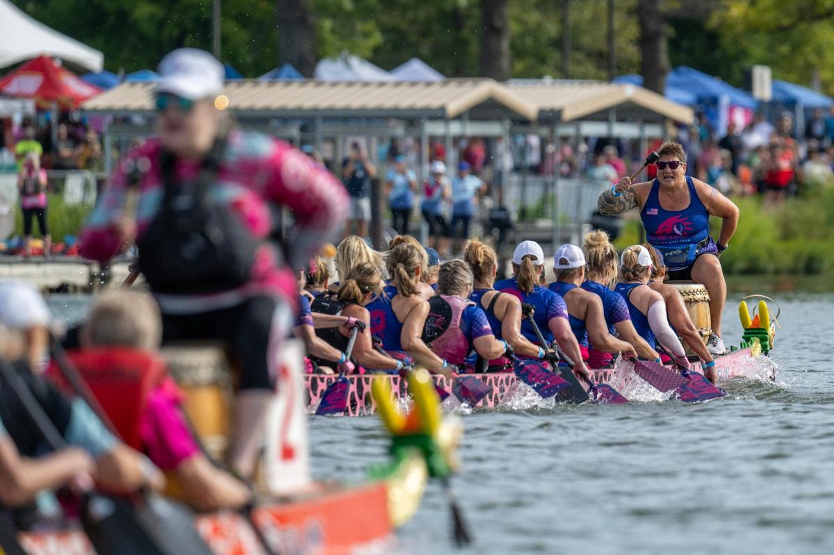 A drummer from KC Pink Warriors leads their crew members in a qualifying race during the KC Dragon Boat Festival on Saturday, Sept. 28, 2024, at Shawnee Mission Park.