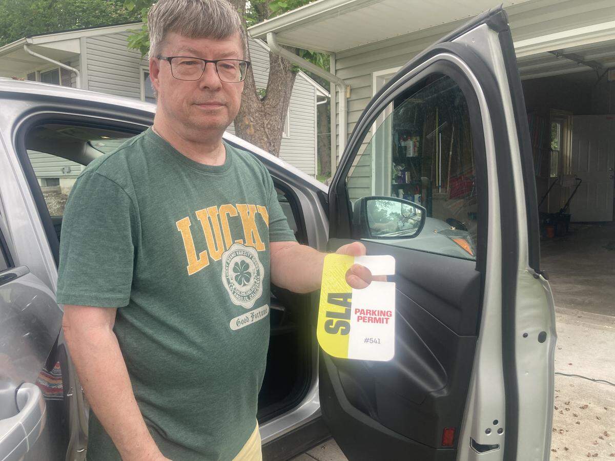 Tim Rasmussen, 72, of Kansas City shows the car tag he was required to get in order to access his neighborhood near Arrowhead Stadium on the six games days in Kansas City during the 2026 FIFA World Cup.