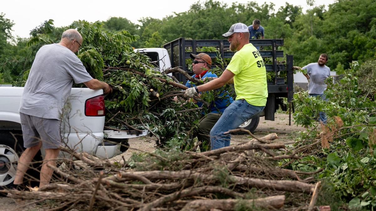 Brett Maasen, right, supervisor of park maintenance, and Mike Hanus, center, park attendant II, pull branches from a pickup bed at Overland Park’s designated storm debris drop off site at 11921 Hardy St. on Monday, July 17, 2023, in Overland Park, Kan. Overland Park residents were allowed to dump tree debris downed by Friday’s major storm for free. The site will be open again this weekend. Other local municipalities have opened similar disposal sites or have made other arrangements to help homeowners clear their yards of debris.