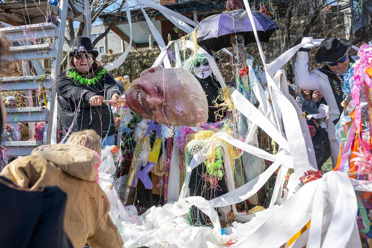 Children use silly string, toilet paper and confetti to cover Maximón, the patron saint of bad behavior, during the Krewe de Prank parade on Sunday, March 2, 2025, in Kansas City.
