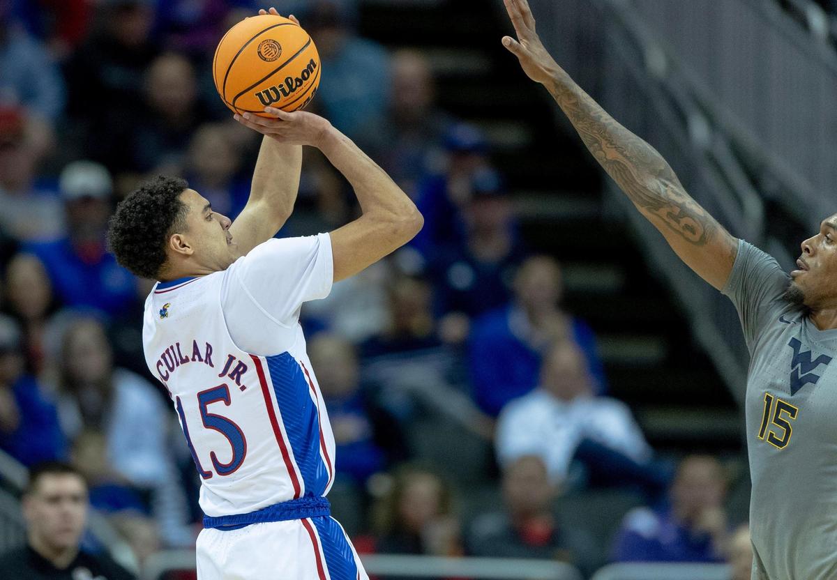 Kansas guard Kevin McCullar Jr. (15) shoots over West Virginia forward Jimmy Bell Jr. (15) during an NCAA college basketball game in the second round of the Big 12 Conference tournament Thursday, March 9, 2023, in Kansas City.