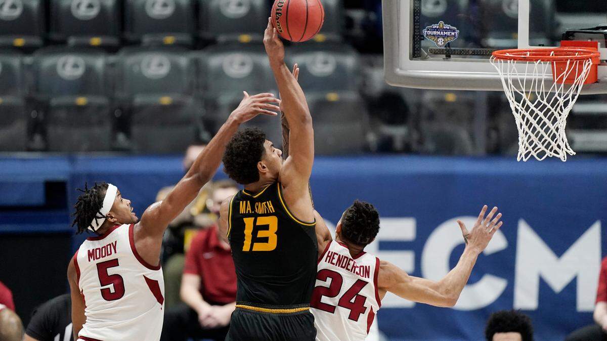 Missouri’s Mark Smith (13) drives to the basket against Arkansas’ Moses Moody (5) and Ethan Henderson (24) in the first half of an NCAA college basketball game in the Southeastern Conference Tournament Friday, March 12, 2021, in Nashville, Tenn. (AP Photo/Mark Humphrey)