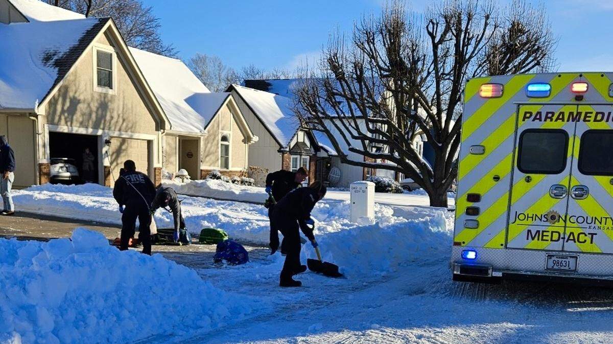 Overland Park Firefighters work to shovel a man’s driveway after he was taken to the hospital Tuesday morning.