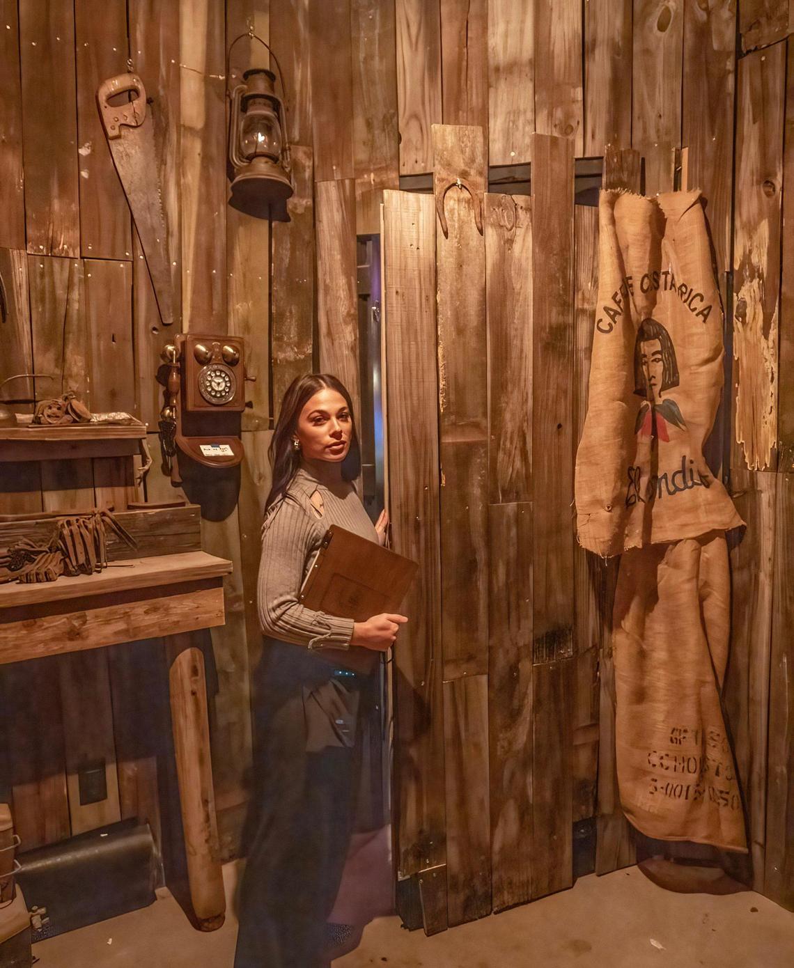 Hostess Summer Ward at the entrance to The Forge. Guests pick up the rotary phone to gain access to the bar.