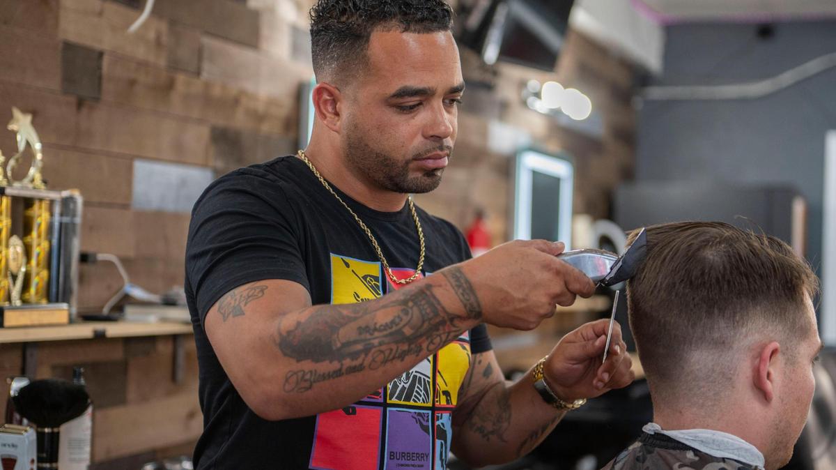 Draque Murff gives a client a haircut at his Draque’s Barbershop. Murff used to place high-dollar wagers on sporting events but stopped and now uses his time and money to serve the community.
