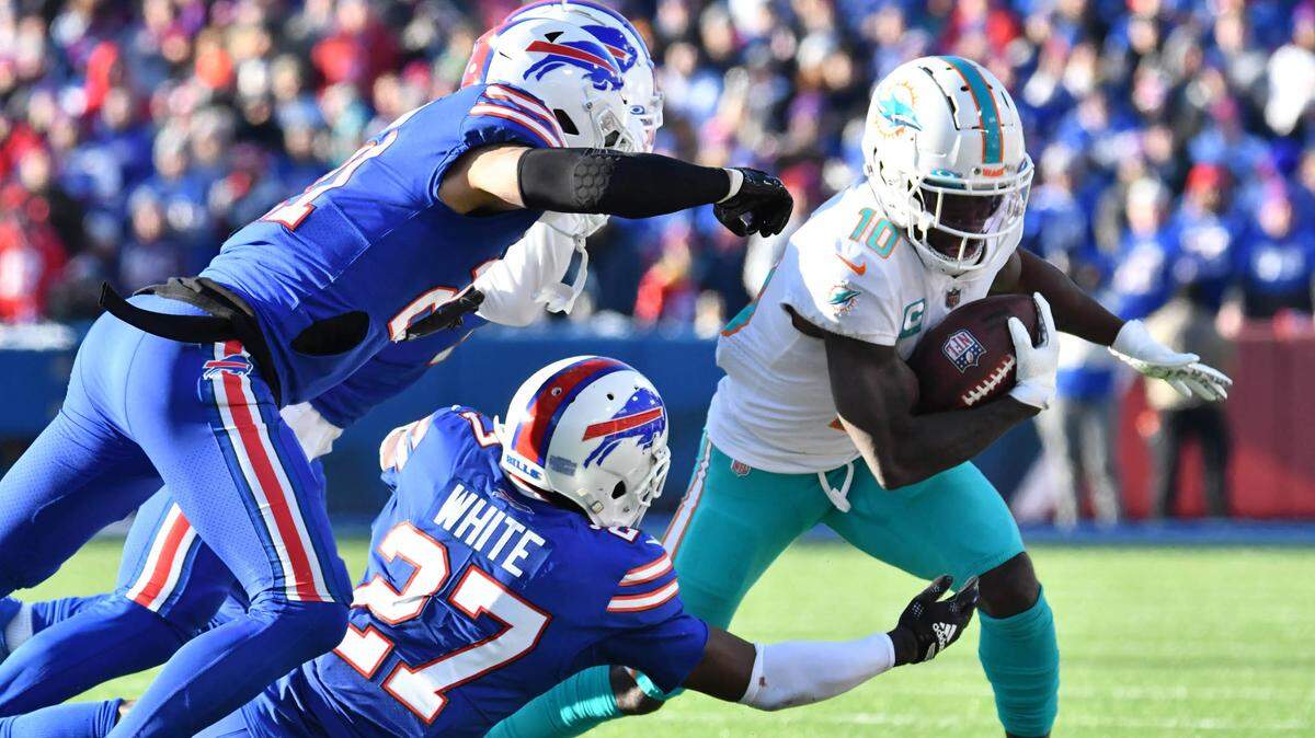 Miami Dolphins wide receiver Tyreek Hill (10) tries to get away from Buffalo Bills cornerback Tre’Davious White (27) and safety Jordan Poyer (21) and cornerback Taron Johnson (7) during the first half in a NFL wild card game at Highmark Stadium.