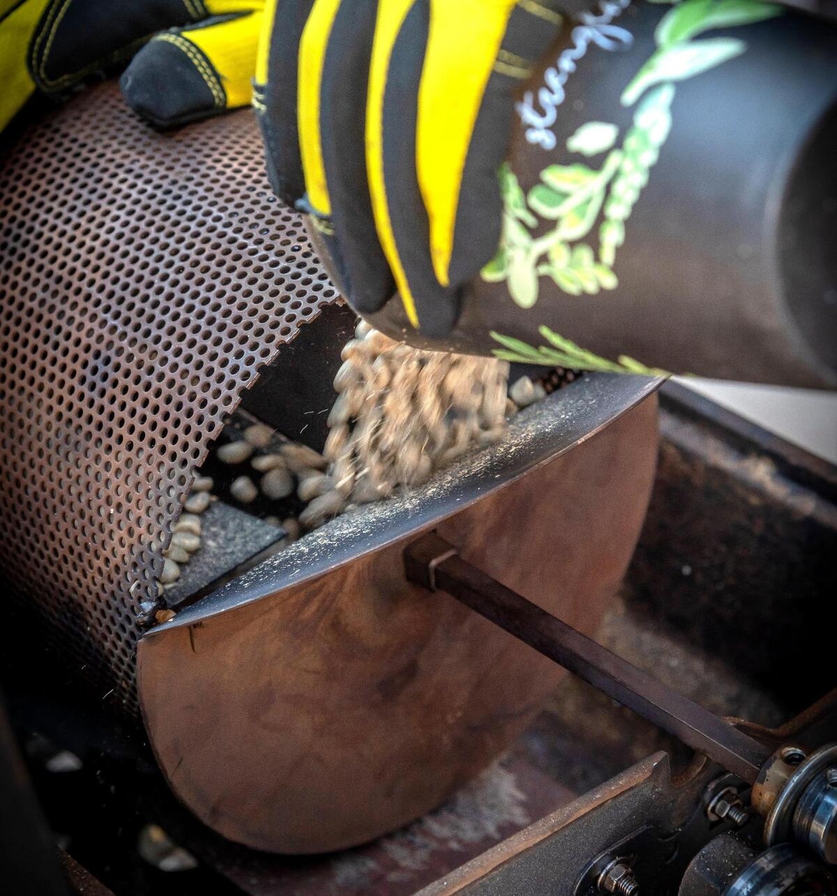 Brent Rice loads coffee beans in the roasting cylinder.
