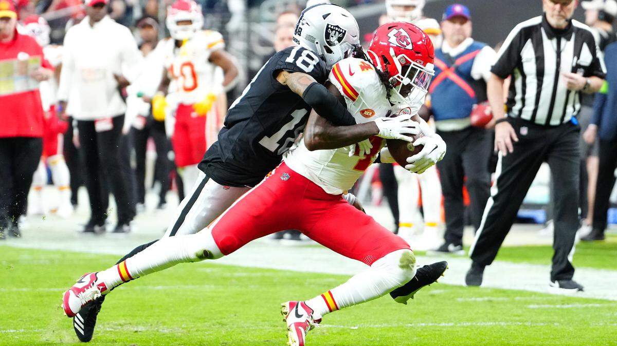 Kansas City Chiefs wide receiver Rashee Rice (4) is tackled by Las Vegas Raiders cornerback Jack Jones (18) during the second quarter at Allegiant Stadium.