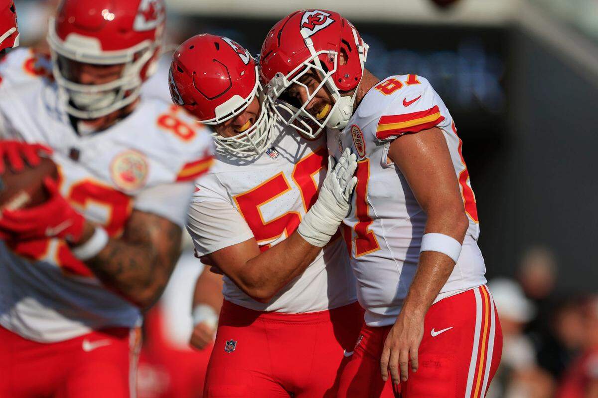 Kansas City Chiefs defensive end George Karlaftis (56) hugs tight end Travis Kelce (87) before a preseason NFL football game Saturday, Aug. 10, 2024 at EverBank Stadium in Jacksonville, Florida.