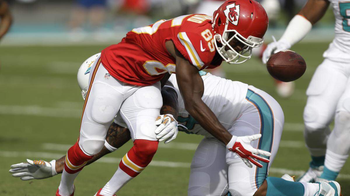 Kansas City Chiefs wide receiver Frankie Hammond (85) attempts to gain control of the ball as Miami Dolphins defensive tackle Randy Starks (94) attempts to tackle during the first half of an NFL football game, Sunday, Sept. 21, 2014, in Miami Gardens, Fla. 