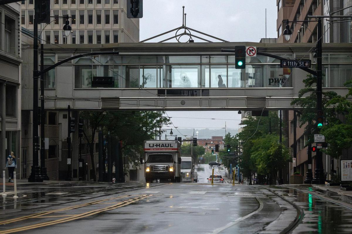 Commuters make their way down 11th Street in downtown Kansas City on Tuesday, June 3, 2025, as rain moves through the area.