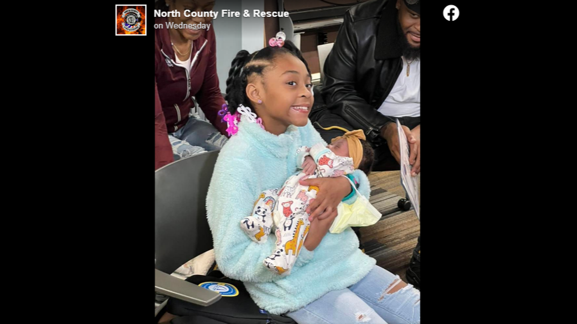 A 10-year-old girl named Miracle holds her newest baby sister, Jayla. Miracle helped coach her mom through an early delivery, officials said.