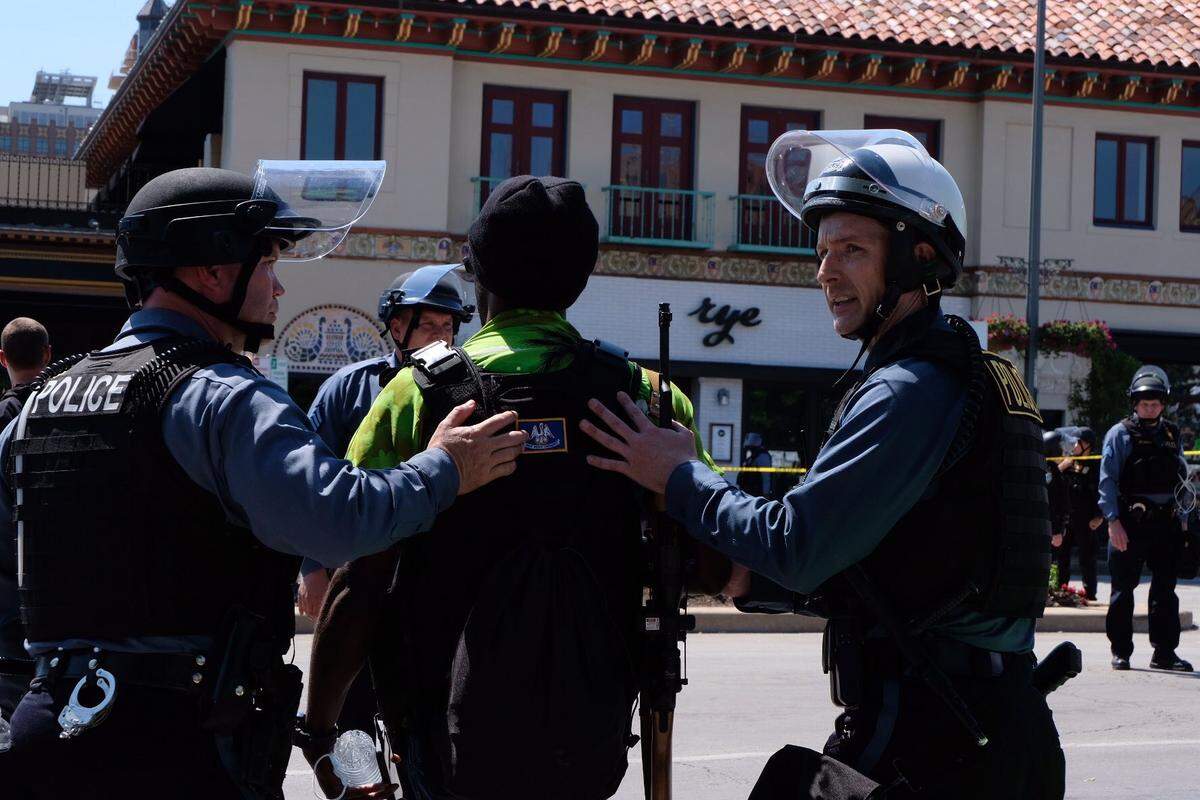 A man who appeared to be armed was led away by police during a protest Sunday at the Country Club Plaza in Kansas City.