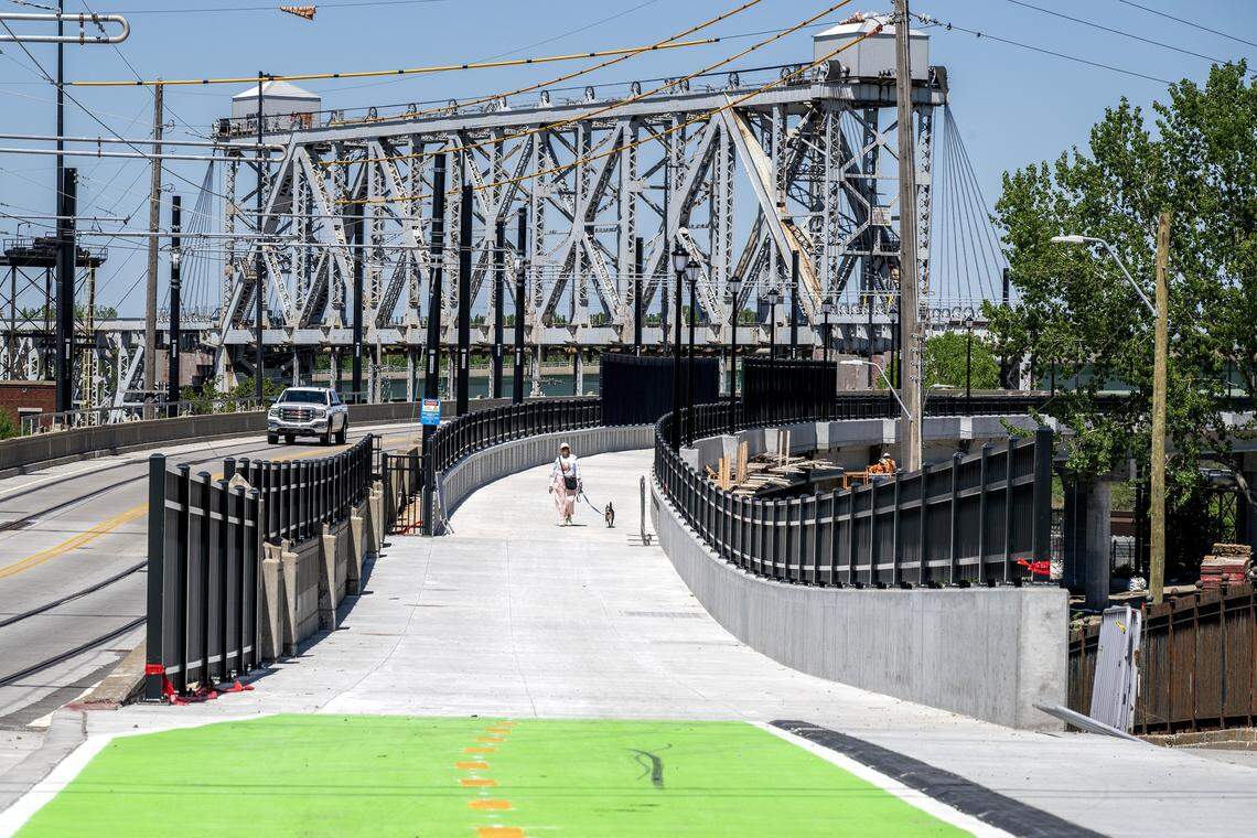 A person walks a dog along the Grand Boulevard Pedestrian/Bike Bridge on Monday, April 20, 2026, in Kansas City.