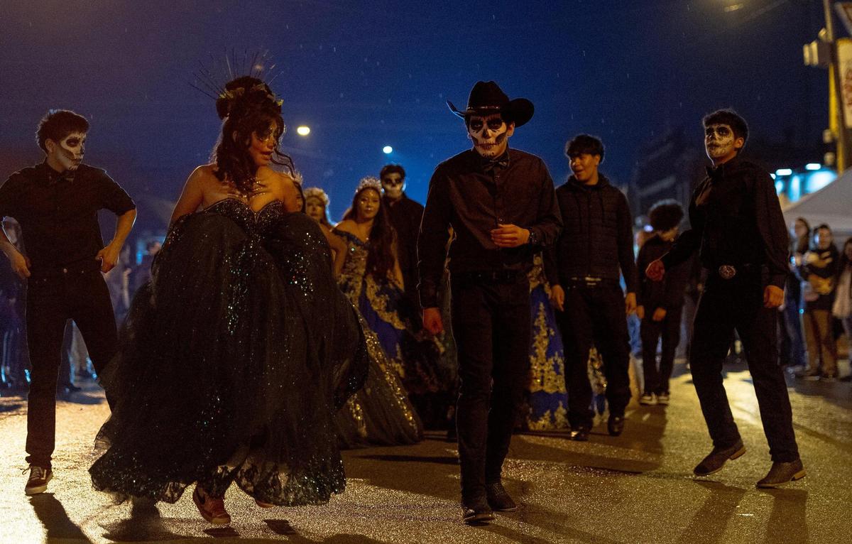 Members of Baila KC perform during the Dia de los Muertos parade hosted by the Central Avenue Betterment Association on Saturday in Kansas City, Kan.
