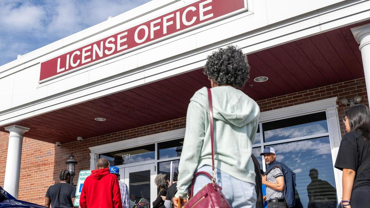 People wait in line outside the Kansas City DMV on Wednesday, May 7, in Kansas City. The line formed early as the office reached capacity, with many waiting to apply for Real IDs.