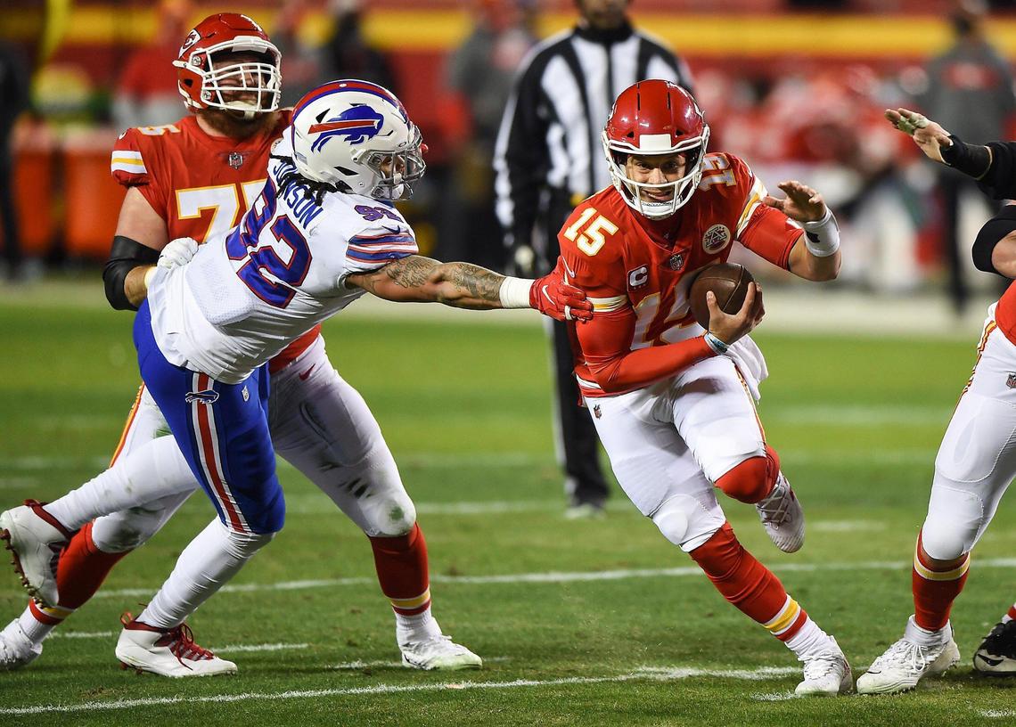 Kansas City Chiefs quarterback Patrick Mahomes scrambles out of the grasp of Buffalo Bills defensive end Darryl Johnson in the second quarter Sunday, January 24, 2021, during the AFC Championship Game at Arrowhead Stadium in Kansas City, Missouri.
