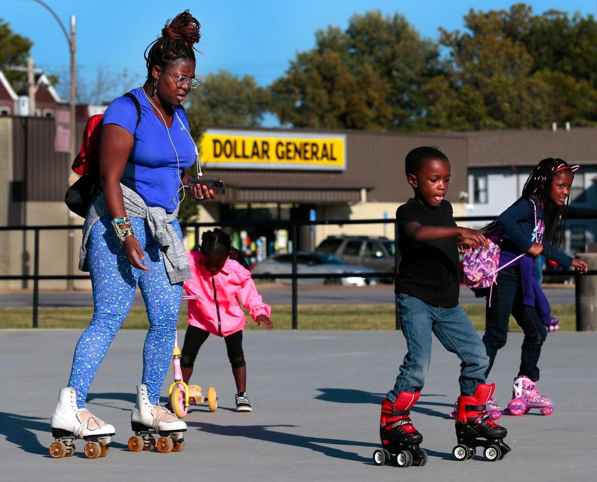 Across the street from a Dollar General store where clerk Robert Woods was shot and killed in 2018, Kennisha Harris takes her children Harrison, 5 and Khori, 7, roller skating at Fairground Park on N. Grand Boulevard on Wednesday, Sept. 30, 2020. Though the Harris family doesn’t live in the neighborhood, Kennisha likes to expose her kids to the ‘skate culture’, listening to Albert ‘Albizness’ Jacobs as DJ for a ‘Hump Day Skate’.