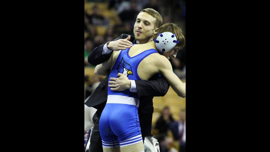 Liberty’s Easton Hilton embraces coach Dustin Brewer shortly after his Class 4 state-title victory at 106 pounds Saturday at Mizzou Arena in Columbia.