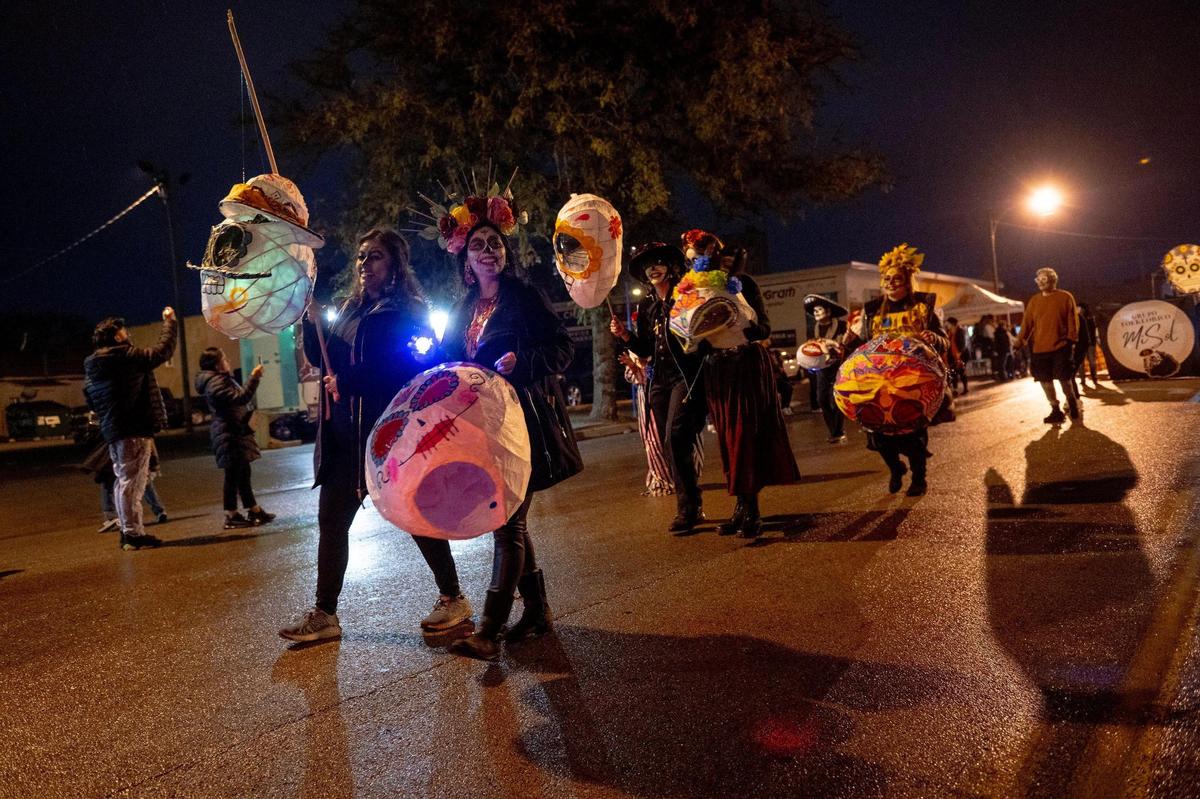 People carry decorative heads during the Dia de los Muertos parade hosted by the Central Avenue Betterment Association on Saturday, Nov. 4, 2023, in Kansas City, Kan.