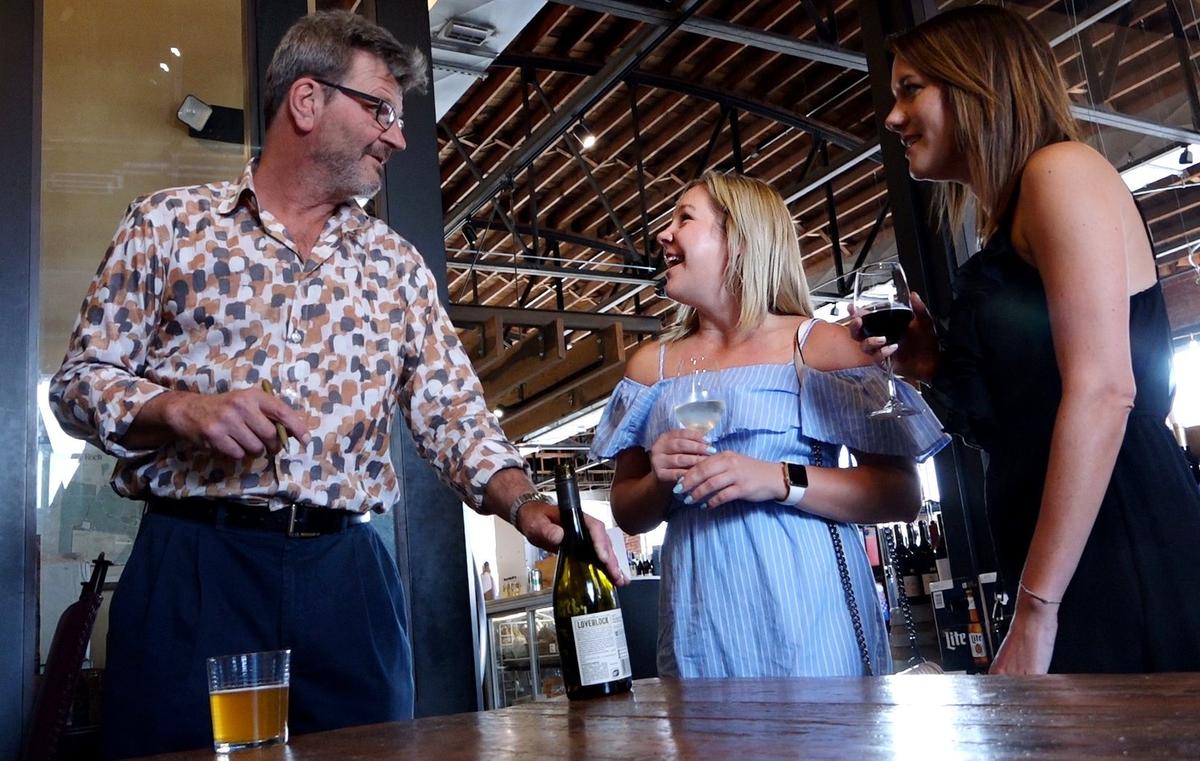 Kirby Hough (center) attends a wine tasting at Cellar Rat Wine Merchants in the Crossroads with her friend Sydney Parks (right). They had a bottle signed by winemaker Kim Crawford (left).