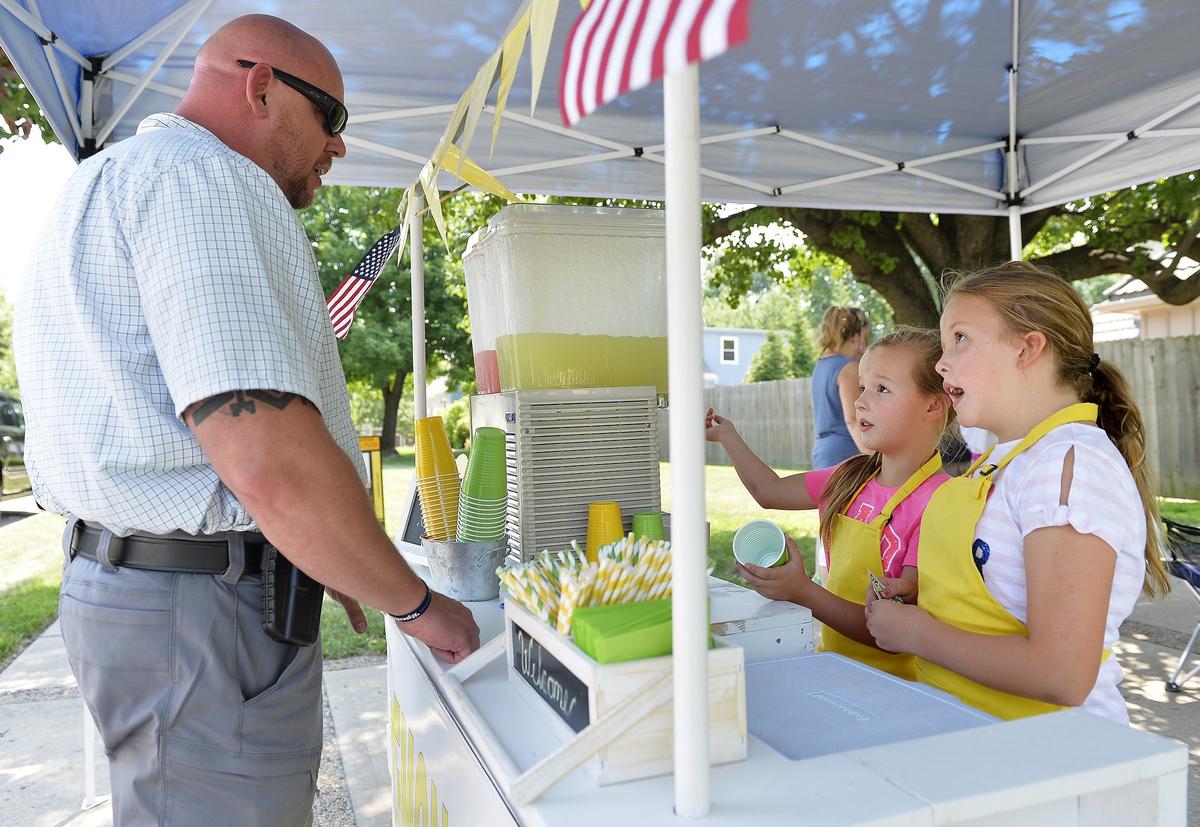 Firefighters and law enforcement brought Leawood sisters Laurin and Kaitlin Stotts gifts of appreciation for opening a lemonade stand to raise money for the families of slain Wyandotte County sheriff's deputies Patrick Rohrer and Theresa King. Capt. Kirk Lane of the Mission Police Department was one of their customers.