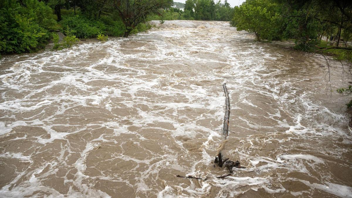 Torrential rains near 103rd and Stateline Road caused Indian Creek to rage, where a large tree trunk flowed by on Monday. More than 1.7 inches of rain fell near there during a 6-hour period ending at 2:30 p.m..